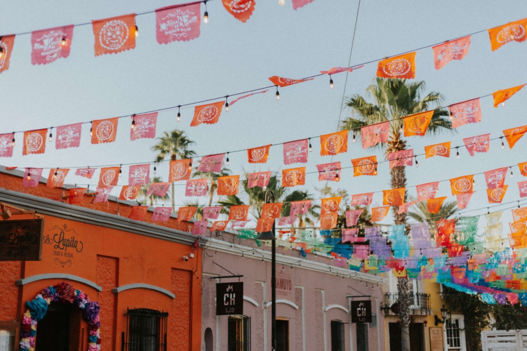 city fiesta celebration flags Cabo San Lucas Fiesta City Block with colorful mexican flags and trees in the sky.