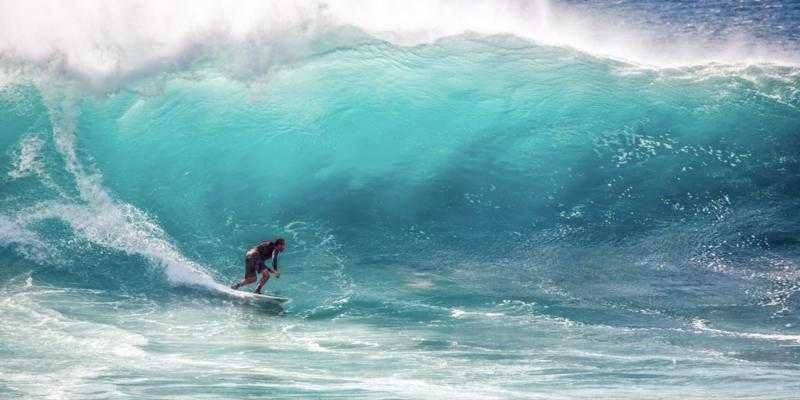 Surfer riding a turquoise wave in Baja California Sur