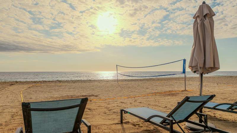 Sunset over Cerritos Beach with loungers and a beach volleyball net