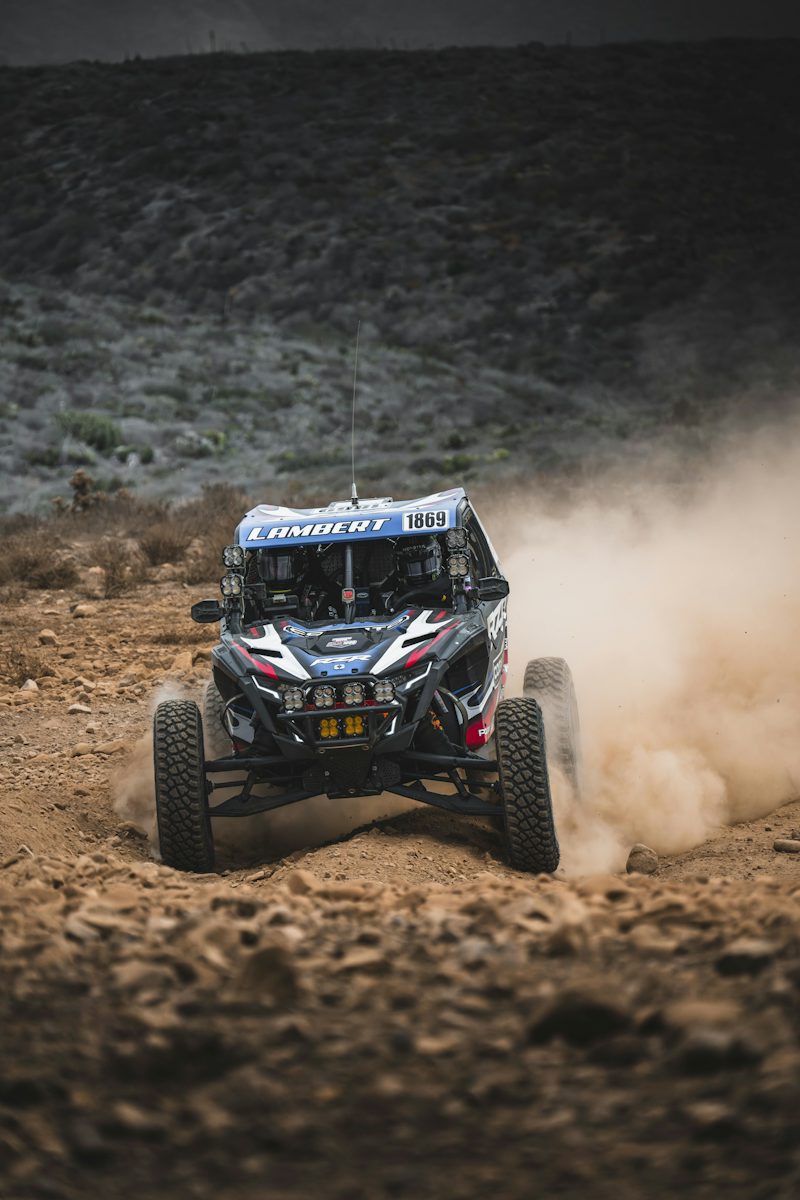 Off-road buggy racing through dust