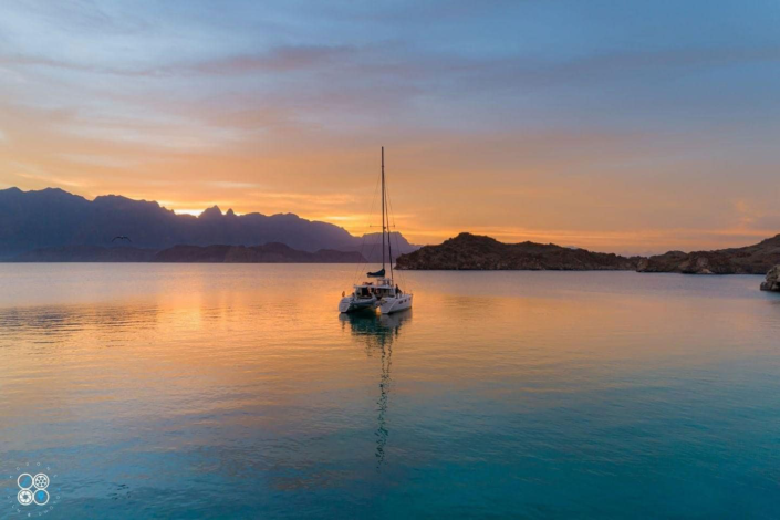 Catamaran on water at sunset