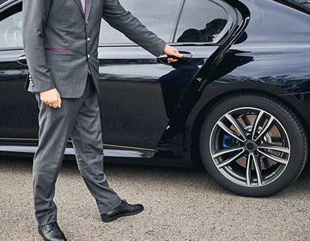 Man in suit opening up a car door