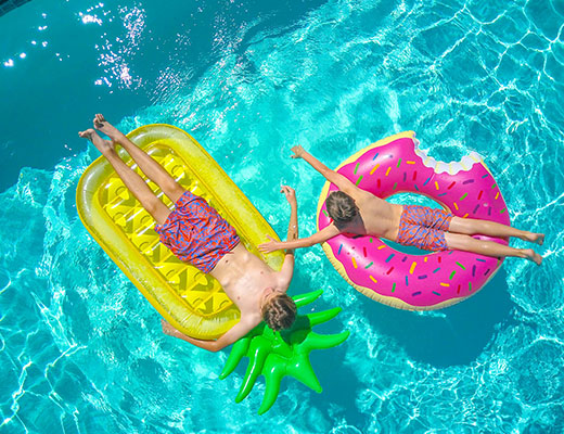 Two kids on floaties in a pool